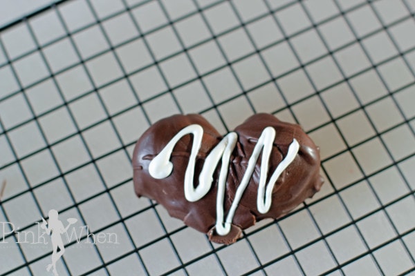 Strawberry Heart covered in chocolate on a wire rack. 