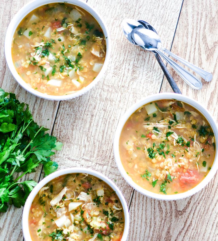 red lentil soup on wood table with spoon