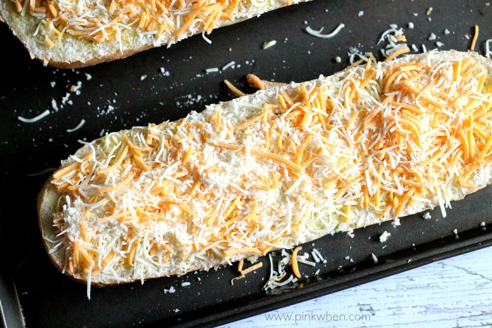 Cheese covered garlic bread on a cookie sheet