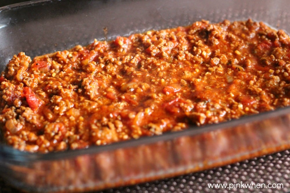 9 x 13 baking dish with meat sauce on bottom