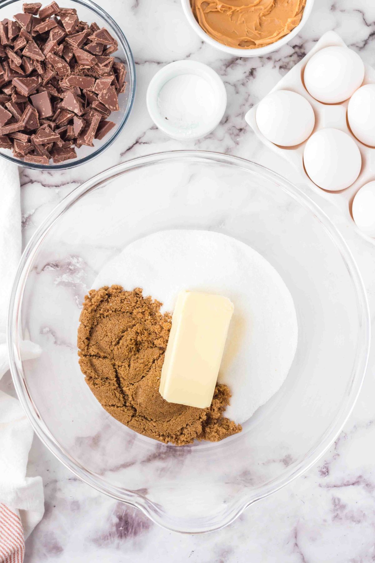 Butter, brown sugar, and sugar in a mixing bowl. 