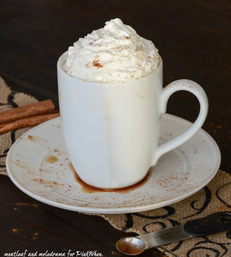 cinnamon-vanilla-with whipped cream in a white cup on a white plate. 