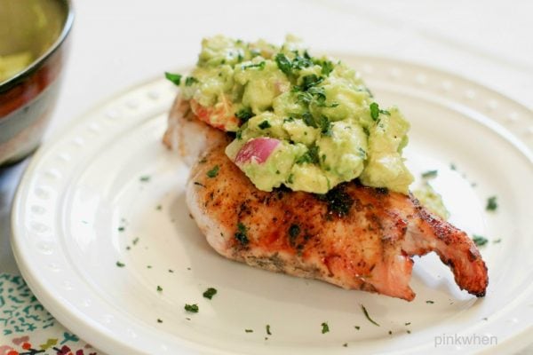 grilled chicken with avocado salsa on a white plate