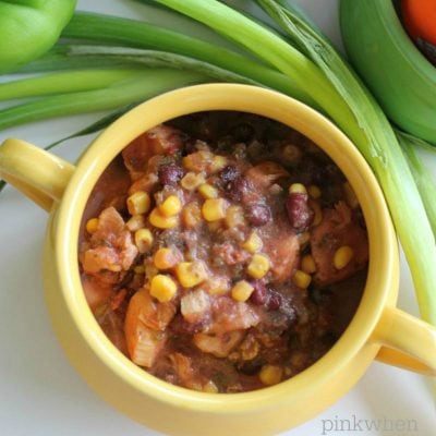 Instant Pot Chicken Taco Soup in a yellow bowl surrounded by vegetables. 