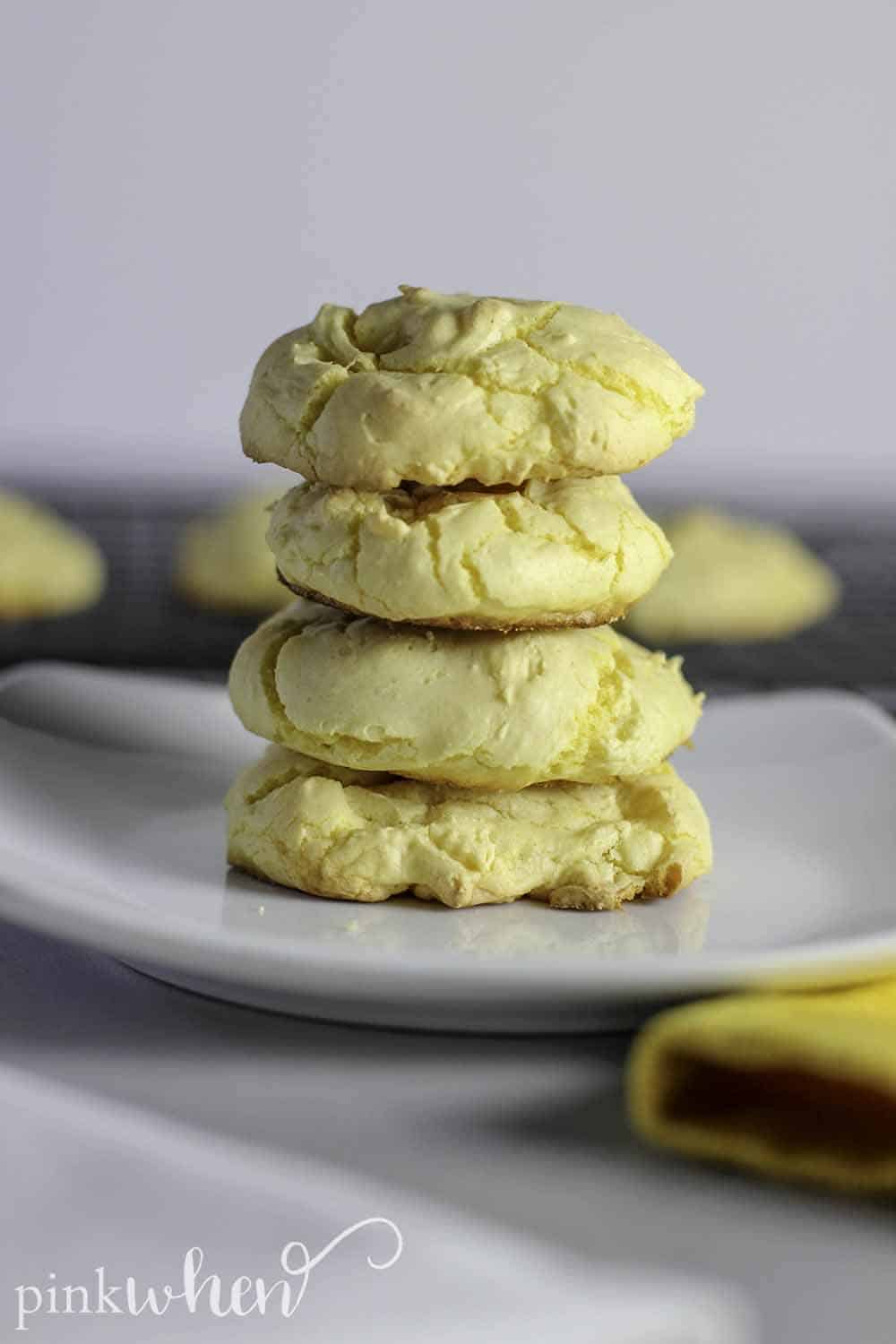Fluffy Lemon Cake Mix Cookies stacked vertically on a white dish. 