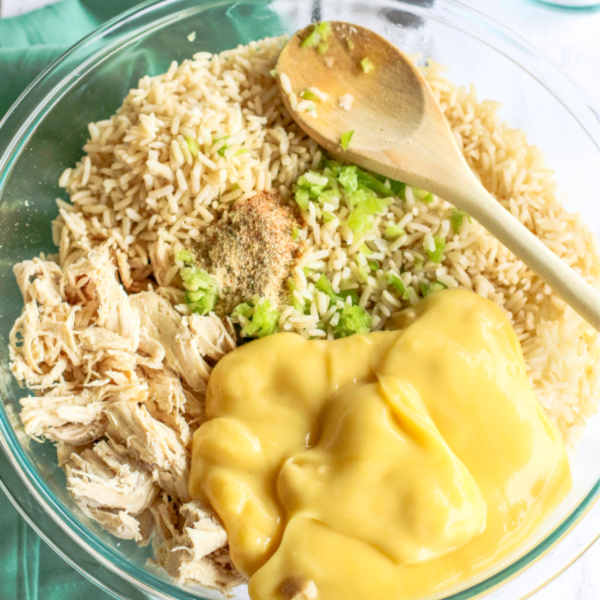 shredded chicken in a dish with ingredients and a wooden spoon