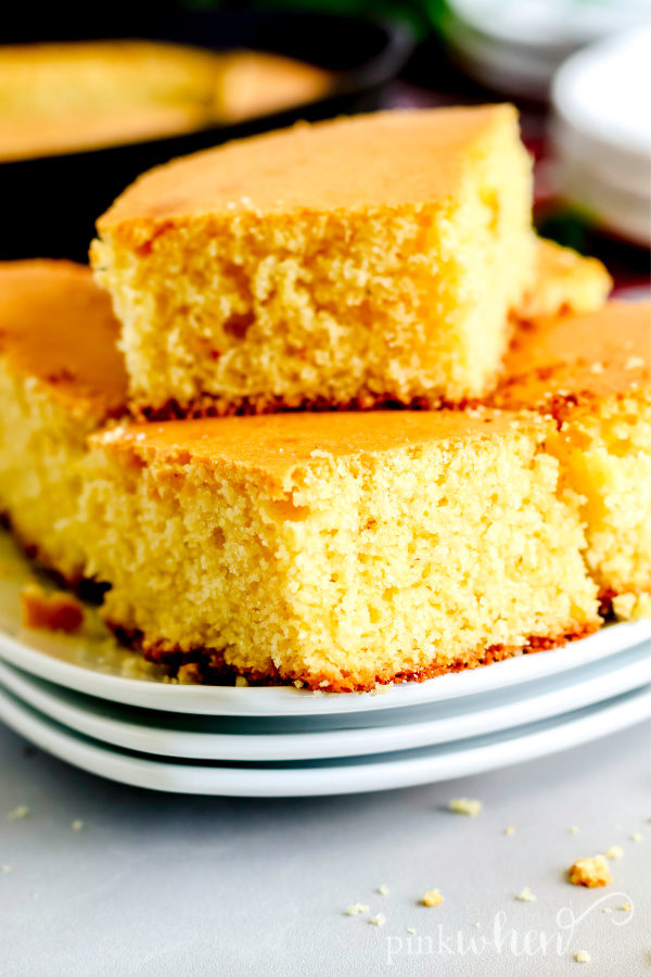 Skillet Cornbread stacked and on a white plate. 