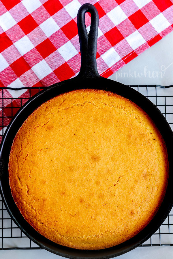 Cornbread cooling in a skillet on a wire rack. 