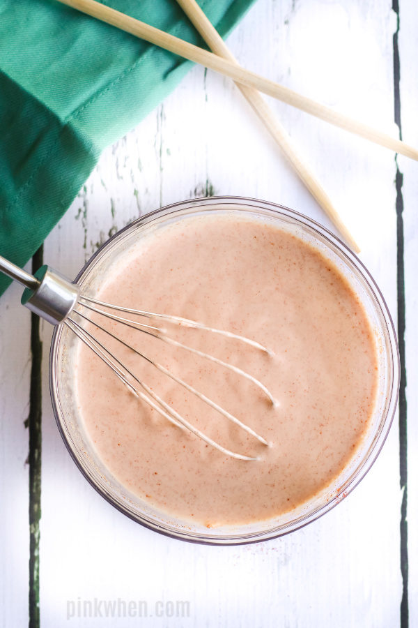 Yum Yum Sauce made in a glass bowl with a wire whisk. 