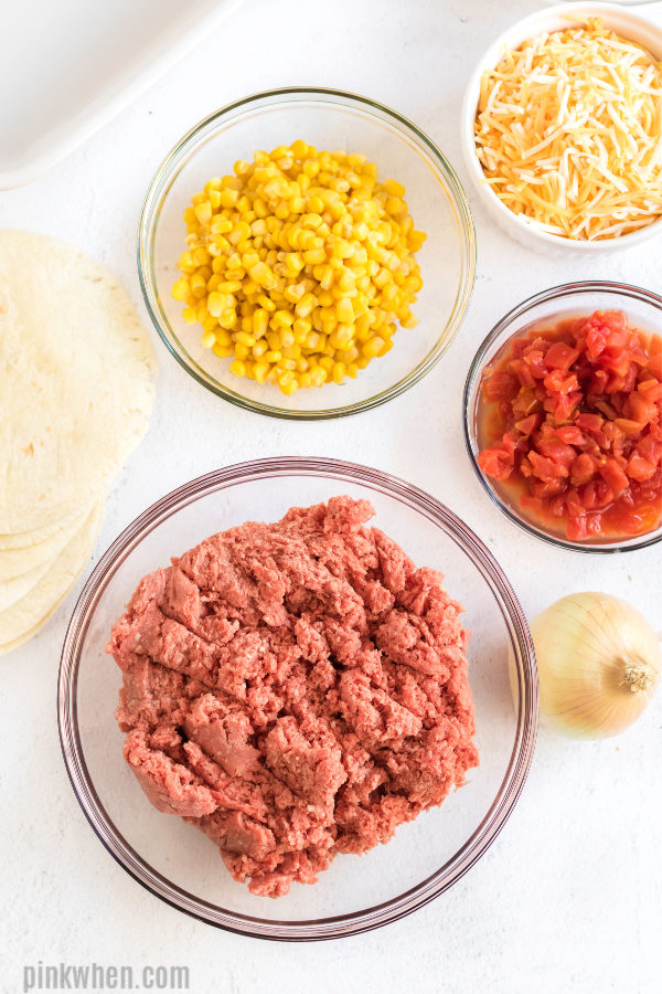 Ingredients needed for Taco Casserole separated into white bowls. 