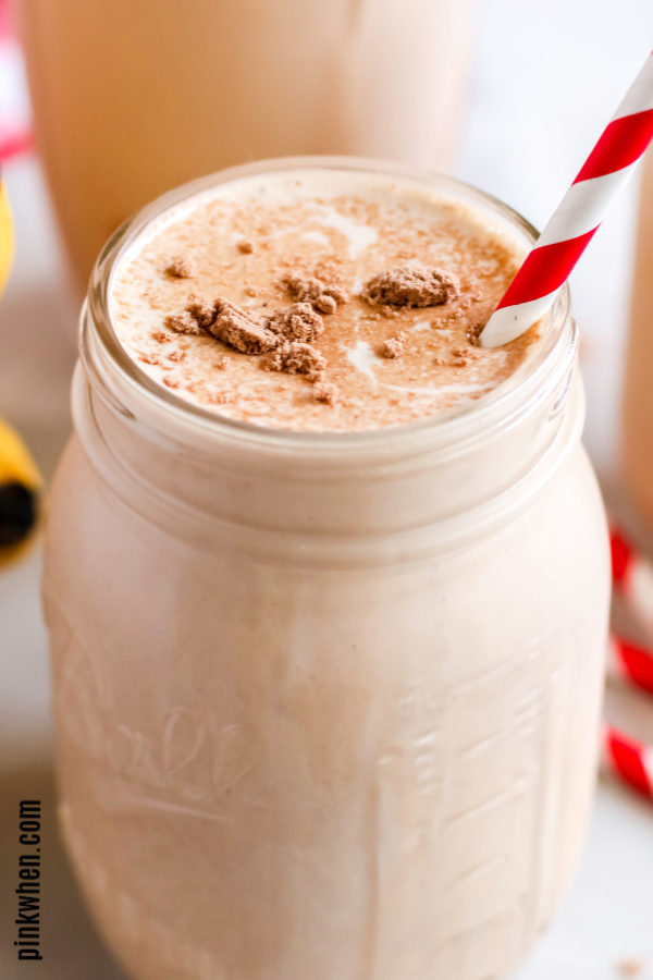 Peanut butter banana smoothie with red and white straw.