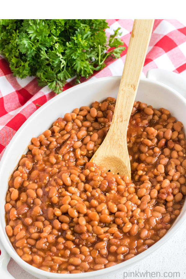 Baked beans with a wooden spoon. 