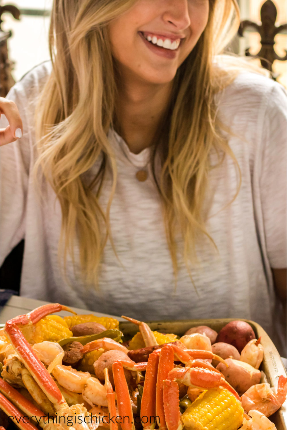 girl about to dig in and eat a tray of food from a seafood boil. 