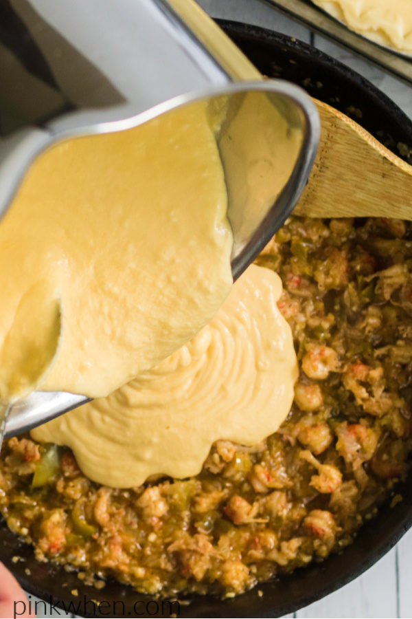 Adding cheese sauce to the pie mixture.