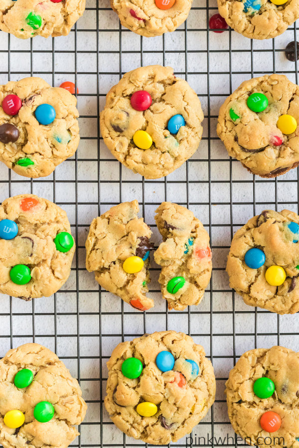 Monster cookies on a cookie rack with a broken cookie in the middle. 