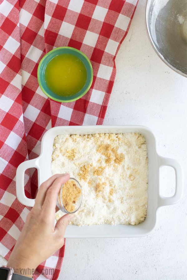 sprinkling brown sugar and cinnamon before baking the cobbler.