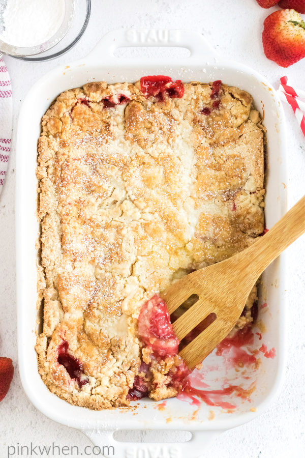 Strawberry dump cake with a scoop missing. 