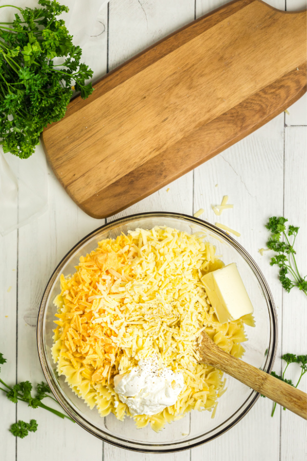 Ingredients for Bowtie mac and cheese added to a bowl. 