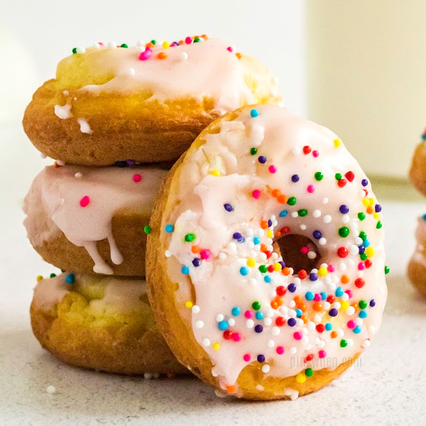 Cake Mix Donuts stacked and covered with icing and sprinkles.
