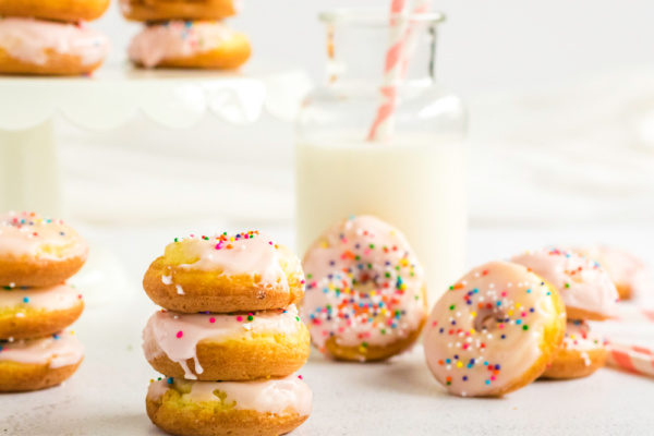 Cake Mix Donuts stacked and ready to serve with a glass of milk.