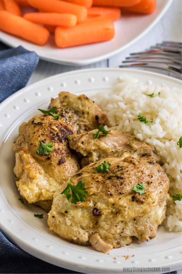 Chicken Thighs made in the Instant Pot on a white plate with rice. 