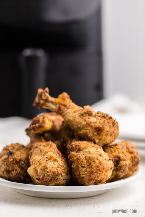 Copycat KFC Chicken on a white plate in front of an Air Fryer.
