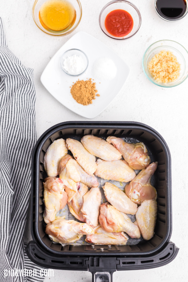 Wings in an air fryer basket ready to cook. 