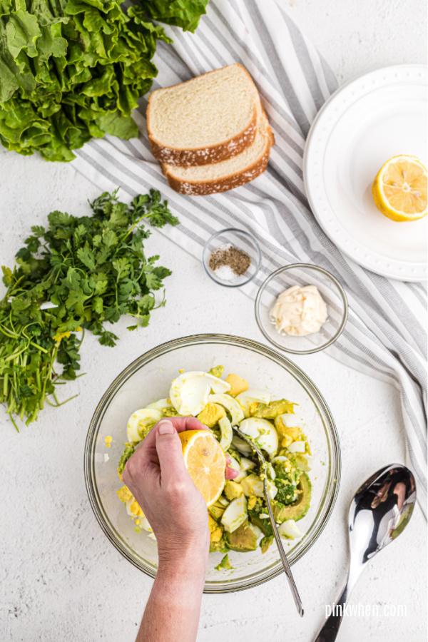 sqeezing fresh lemon juice to avocado egg salad.