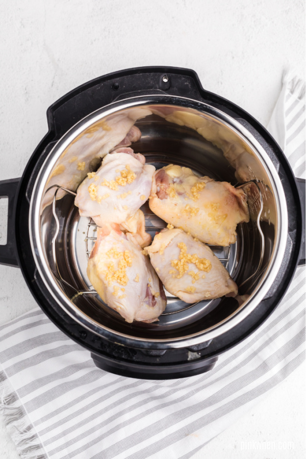 chicken thighs with garlic and set on a trivet in the Instant Pot. 