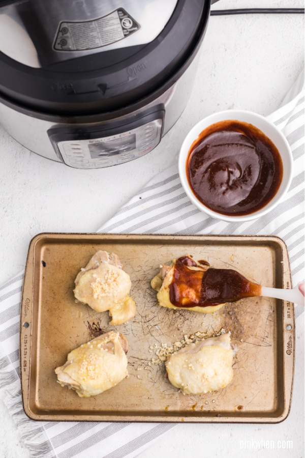 basting seasoned bbq sauce to cooked chicken thighs