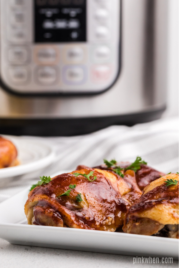 BBQ Chicken Thighs made in the Instant Pot on a white plate.