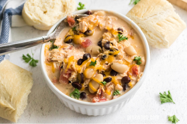 Chicken chili on a white bowl with a spoon and ready to serve. 