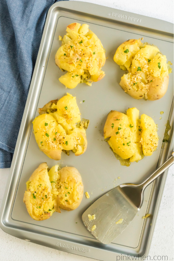 Crispy parmesan garlic smashed potatoes on a cookie sheet. 