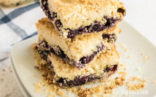 Blueberry crumb bars stacked on a plate. 