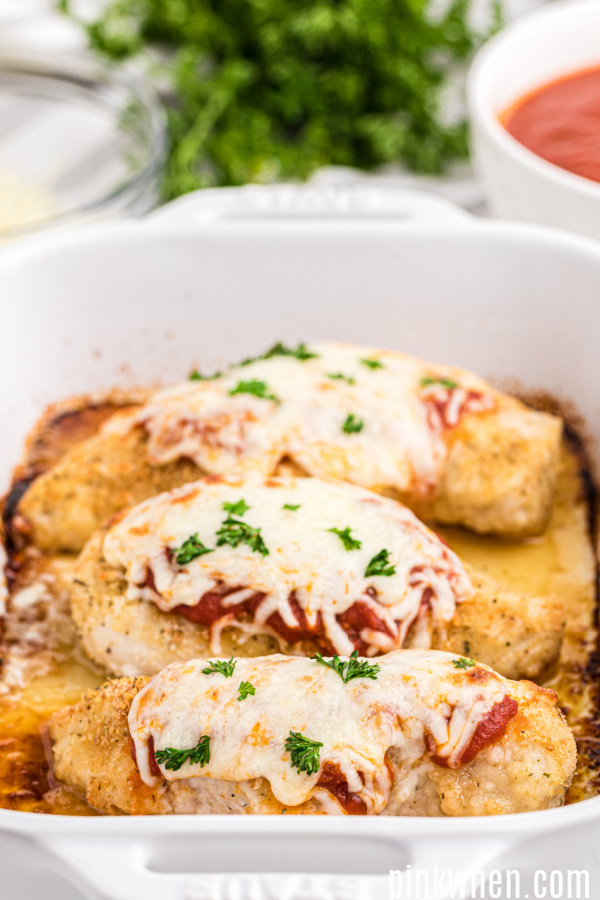 Oven baked parmesan chicken in a dish ready to serve.