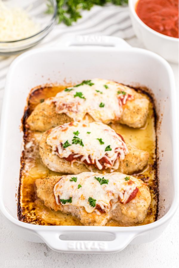 Chicken parmesan in a white baking dish and ready to serve. 