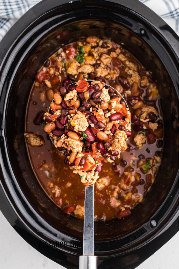 A scoop of turkey chili from a crockpot ready to serve. 