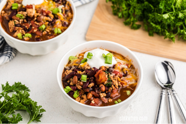 Turkey chili from the crockpot in a white bowl and served with toppings. 
