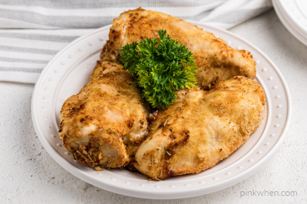Chicken breasts from an air fryer on a white plate.