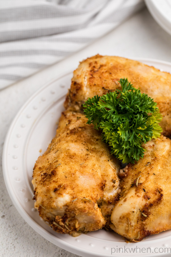 Chicken breasts made in the air fryer on a white plate and ready to serve. 