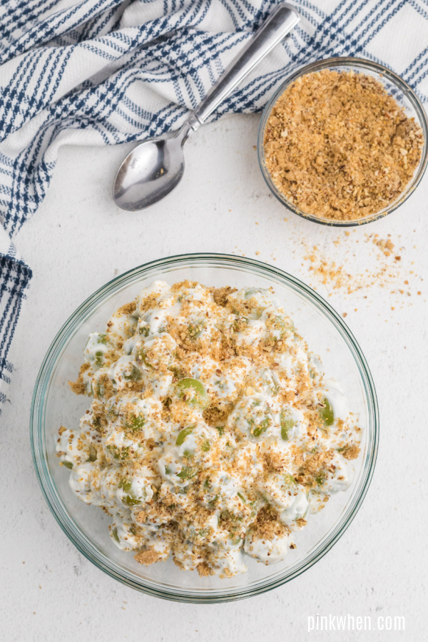 Recipe for grape salad mixed and topped with crumble topping. 