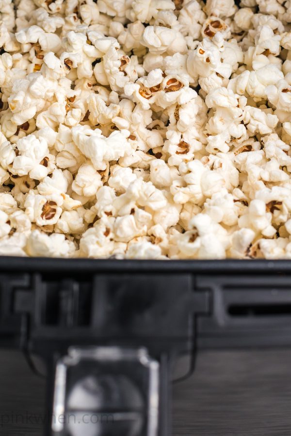 popcorn in an air fryer basket ready to serve.