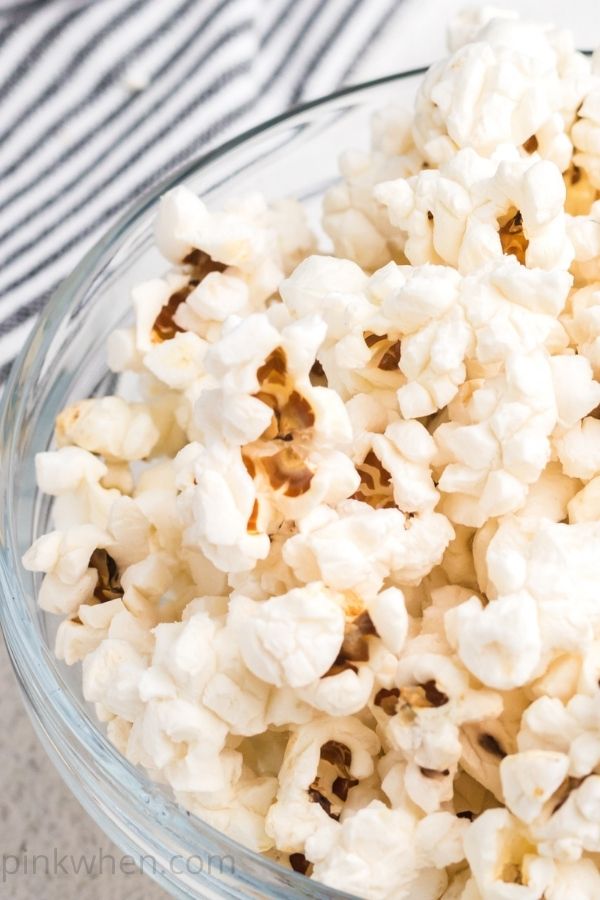 Homemade light and fluffy air fryer popcorn in a clear bowl ready to eat. 