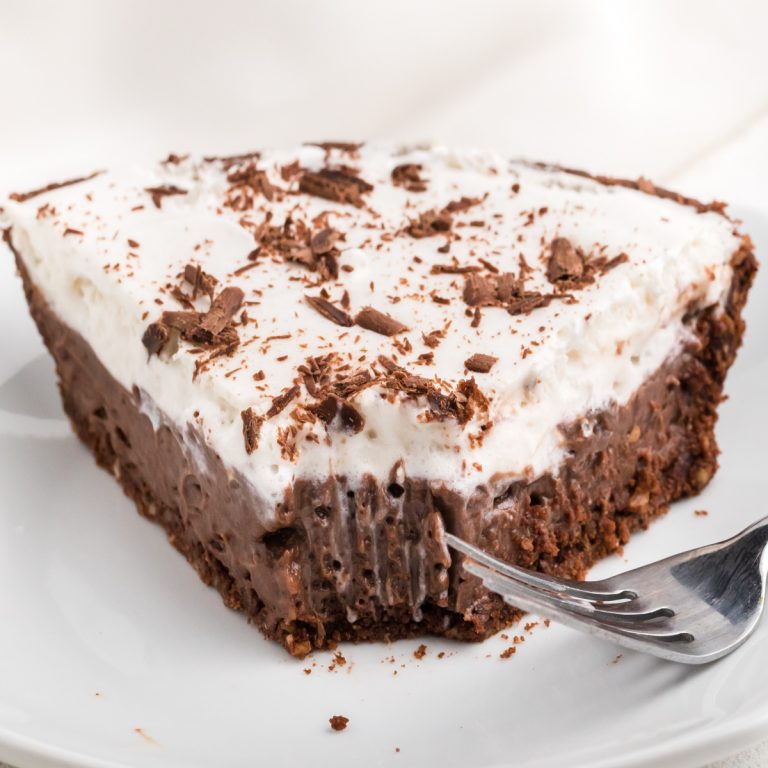 Slice of chocolate pie missing a bite on a white plate.