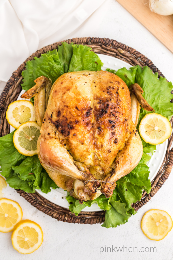 Slow roasted Chicken on a plate with lettuce and lemons. 