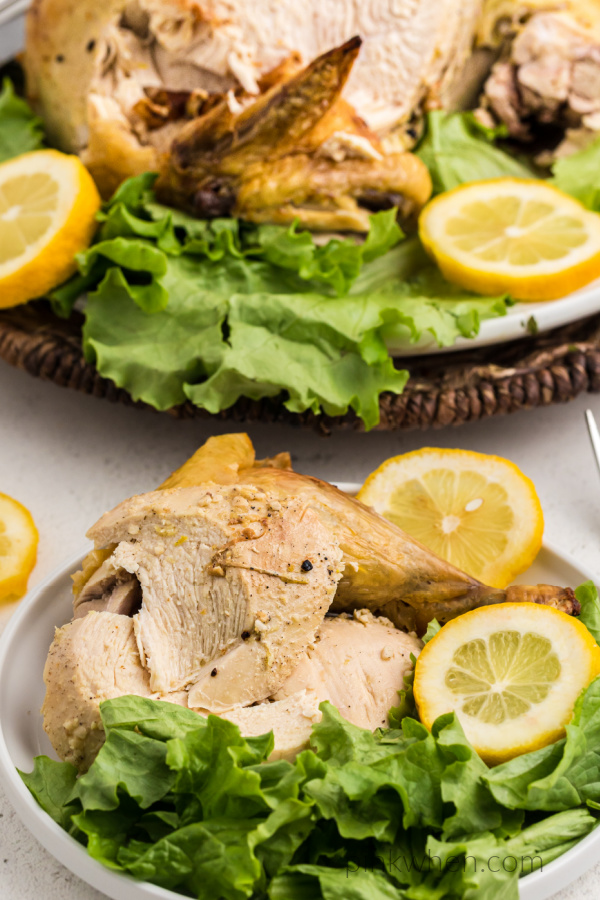 Carved roasted chicken served on a bed of lettuce.
