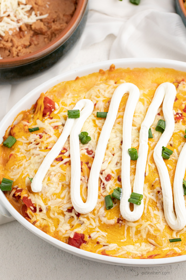 Chicken Taco Casserole topped with sour cream and green onion tops. 