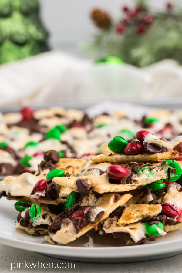 Christmas Cracker Saltines on a white plate with Christmas decor in the background.
