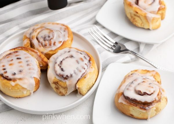 Cinnamon rolls made in the Air Fryer ready to serve on a white plate.