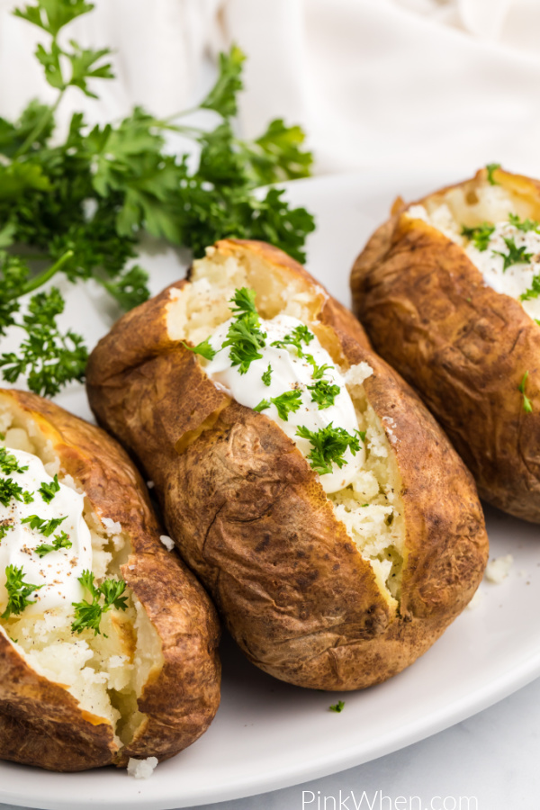Baked potatoes made in the Air Fryer and topped with sour cream and fresh parsley. 
